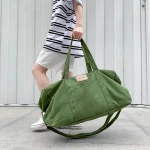 Sac de sport en toile unisexe étanche porté Sac de sport en toile unisexe étanche porté à la main par une femme