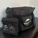 Sac de voyage pliable avec pochette sur une table Sac de voyage pliable avec pochette sur une table