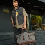 Sac de voyage pour homme en toile et cuir porté main