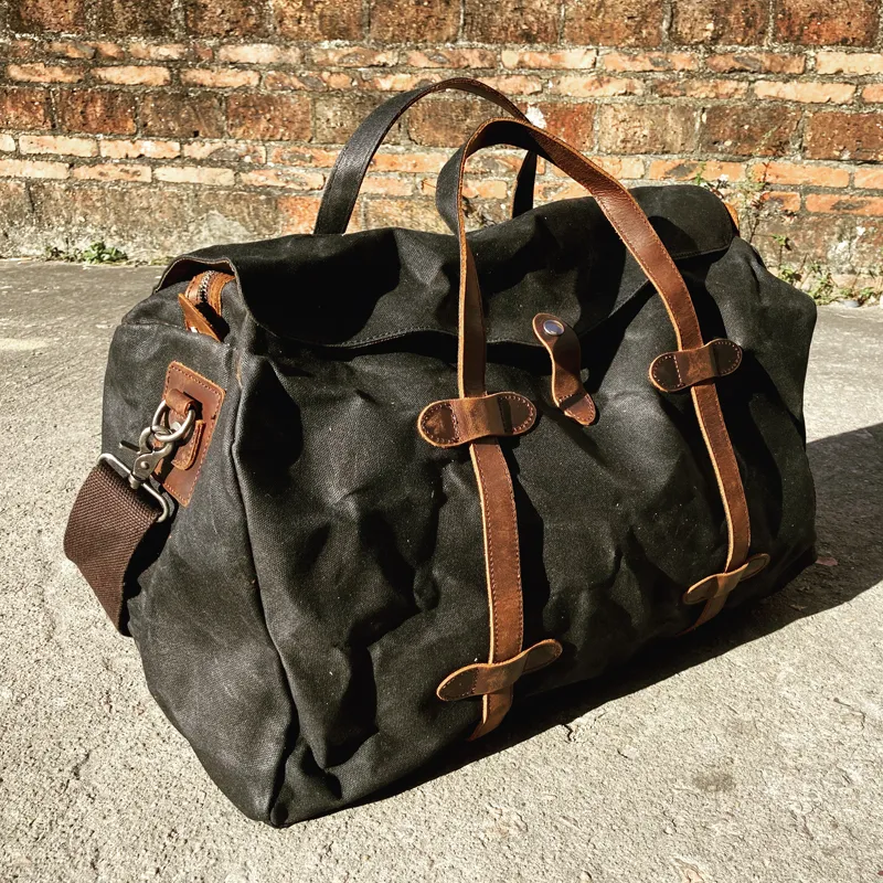 Grand sac voyage en toile style vintage pour escapades et voyages d'affaires noir posé sur le sol