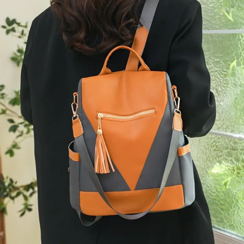 Petit sac à dos tendance anti-volorange et gris porté épaule