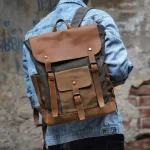 Sac à dos pour homme look vintage en toile cirée et cuir imperméable porté Sac à dos pour homme look vintage en toile cirée et cuir imperméable porté