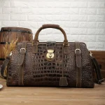 Sac de voyage en cuir pour homme marron sur table Sac de voyage en cuir pour homme marron sur table