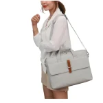 Pochette ordinateur avec poignée et bandoulière gris clair porté femme