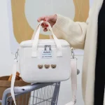 Sac isotherme bébé et maman mignon étanche et résistant blanc sur un caddie Sac isotherme bébé et maman mignon étanche et résistant blanc sur un caddie